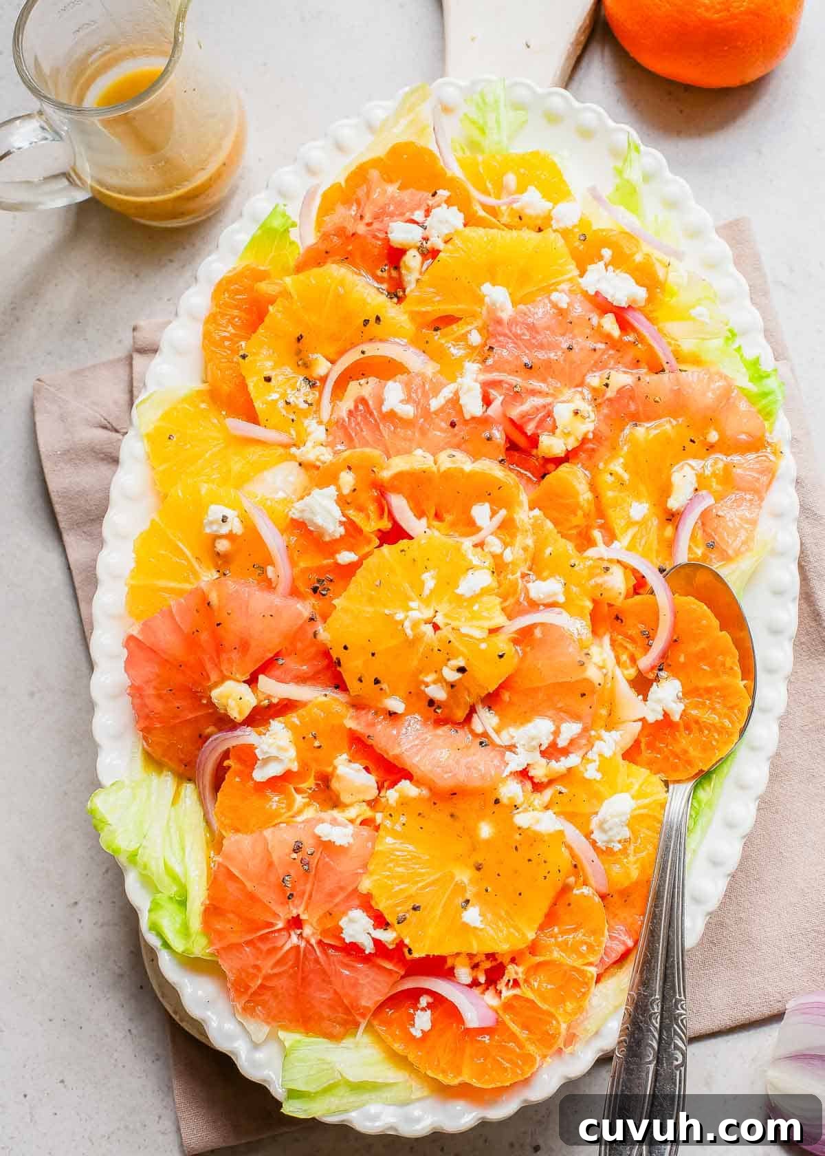 Refreshingly Zesty Citrus Salad Recipe with Honey-Lime Dressing 6 Orange, grapefruit and mandarin salad on a white plate with a spoon.