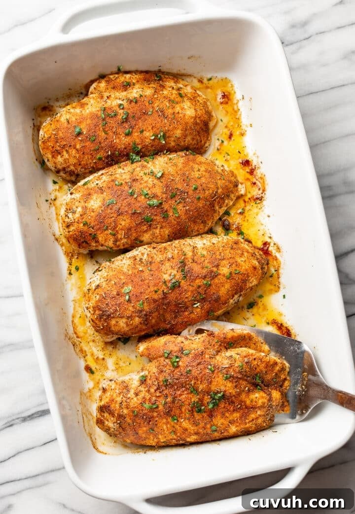 Juicy Oven-Baked Chicken Breast Recipe for Weeknight Dinners 7 a casserole dish with baked chicken breast and a metal spatula