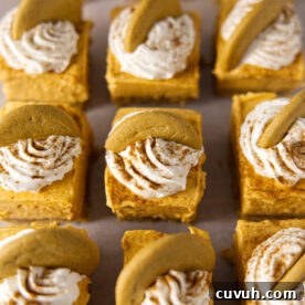 No bake pumpkin cheesecake bars with a gingersnap cookie on top, laid out in a grid.