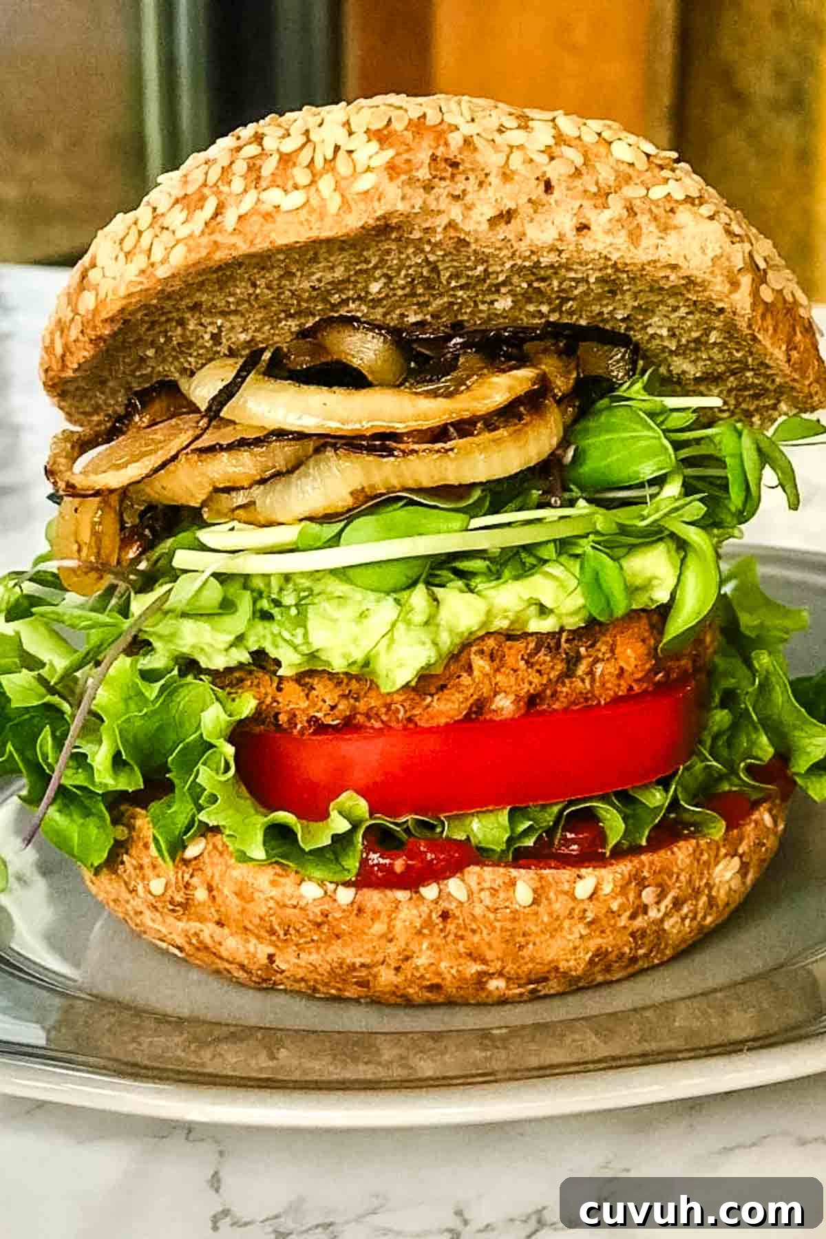 Sweet Potato and Black Bean Burger Recipe for Flavorful Veggie Meals 2 Loaded veggie burger with grilled onions, guacamole, lettuce, tomato and ketchup.