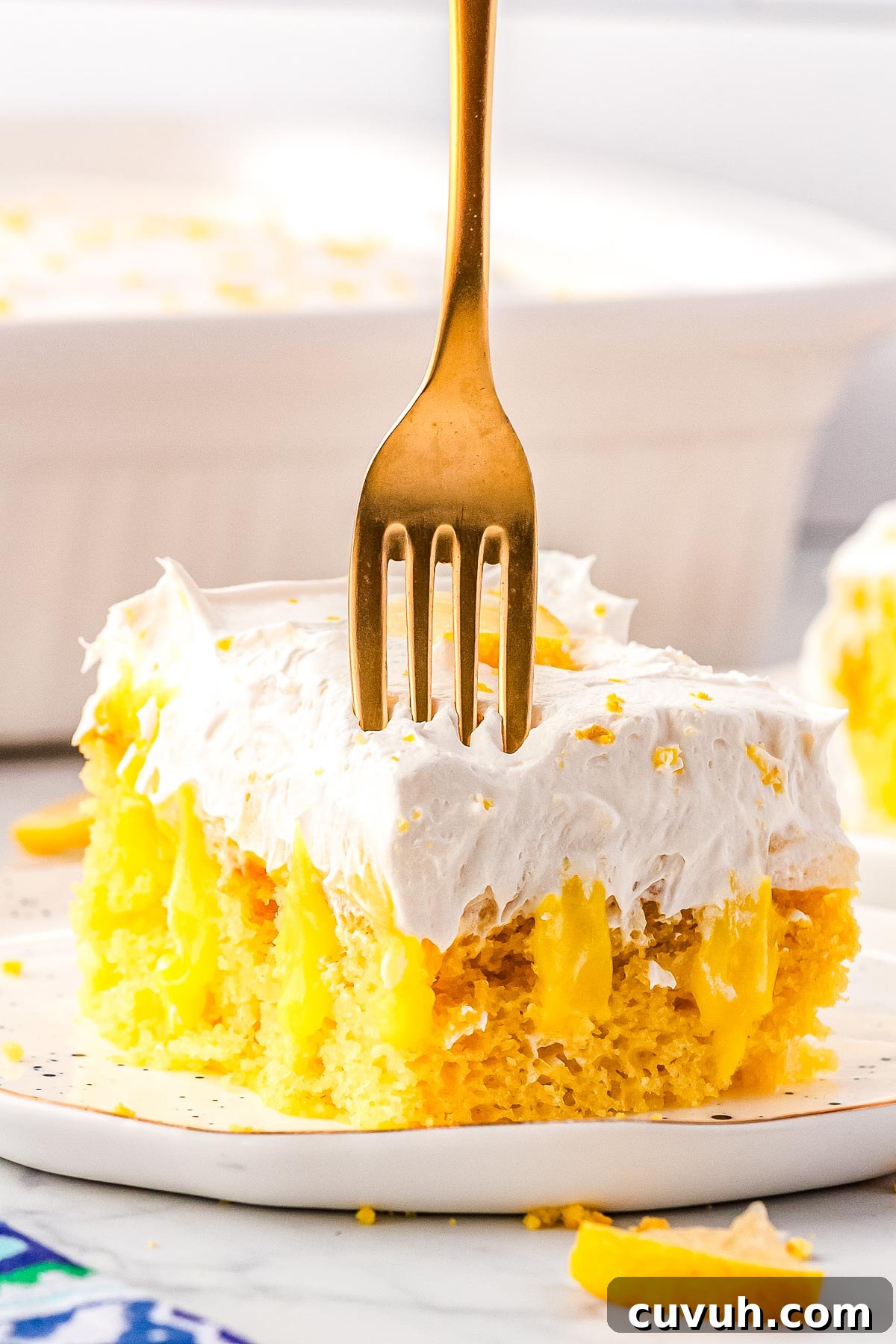 Moist Lemon Poke Cake with Zesty Citrus Glaze 2 A fork digging into the lemon cake.