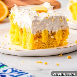 Moist Lemon Poke Cake with Zesty Citrus Glaze 7 A slice of lemon poke cake on a white plate.