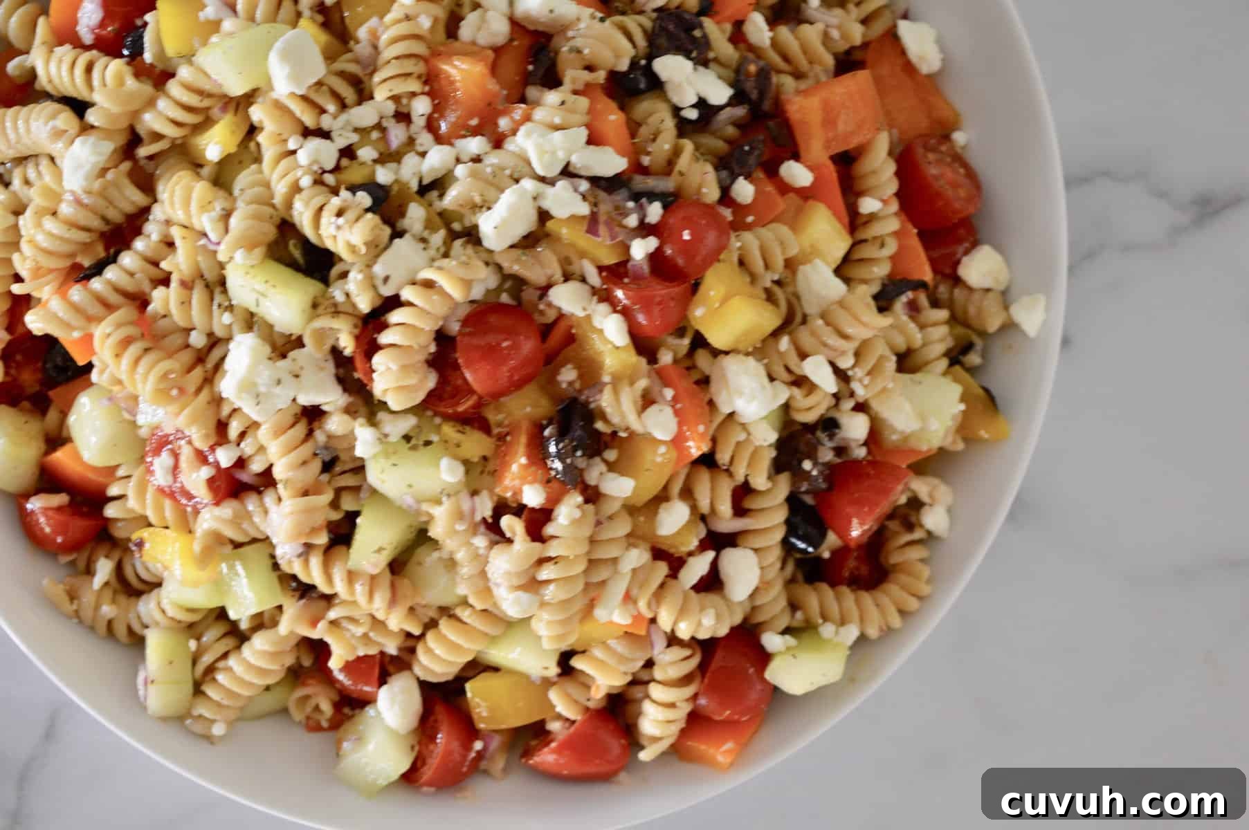 Whole Wheat Greek Pasta Salad with Feta & Olives 3 Whole Grain Greek Pasta Salad in a white bowl.