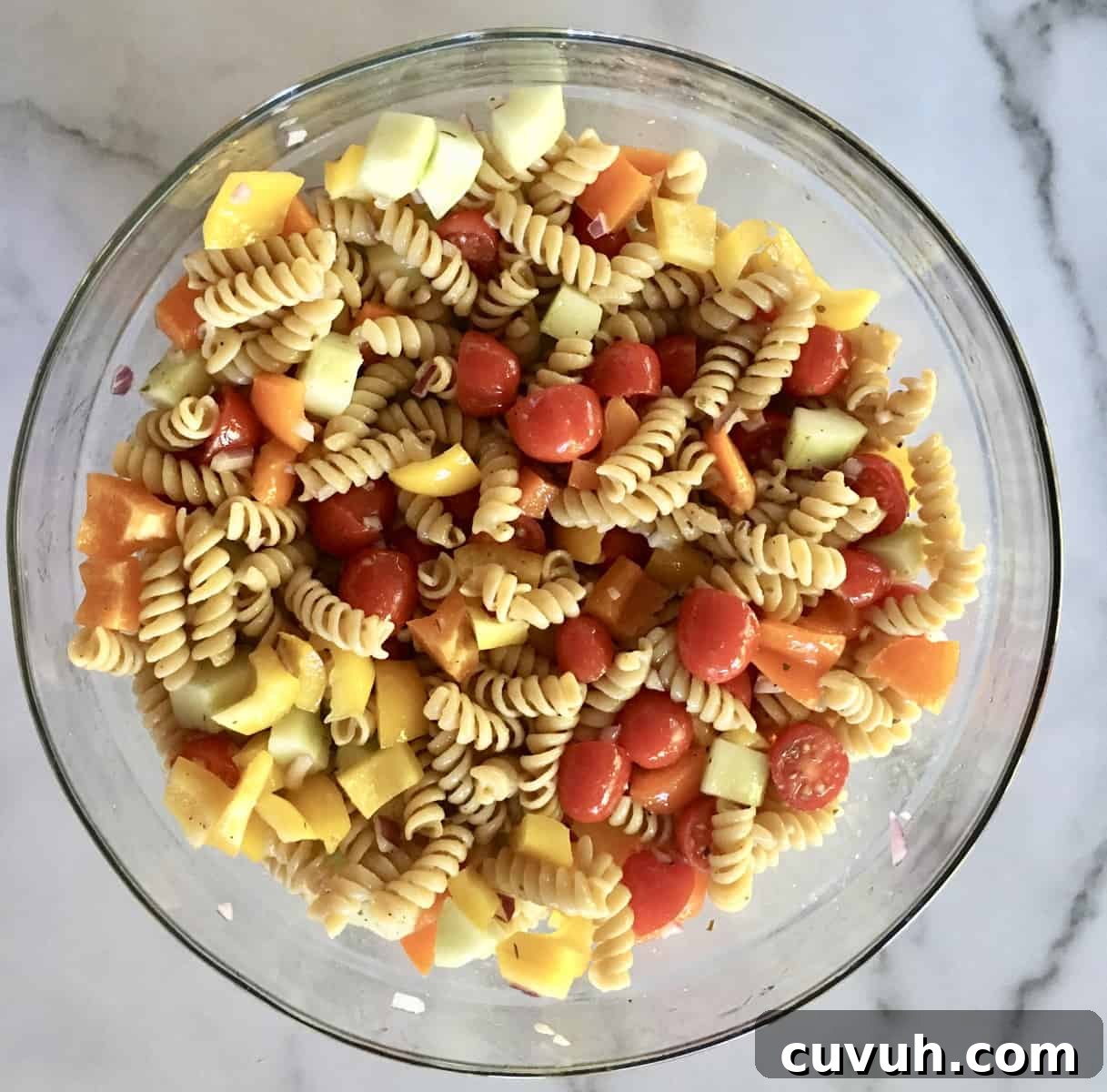 Whole Wheat Greek Pasta Salad with Feta & Olives 5 Glass bowl of tossed ingredients and only half of the greek dressing.