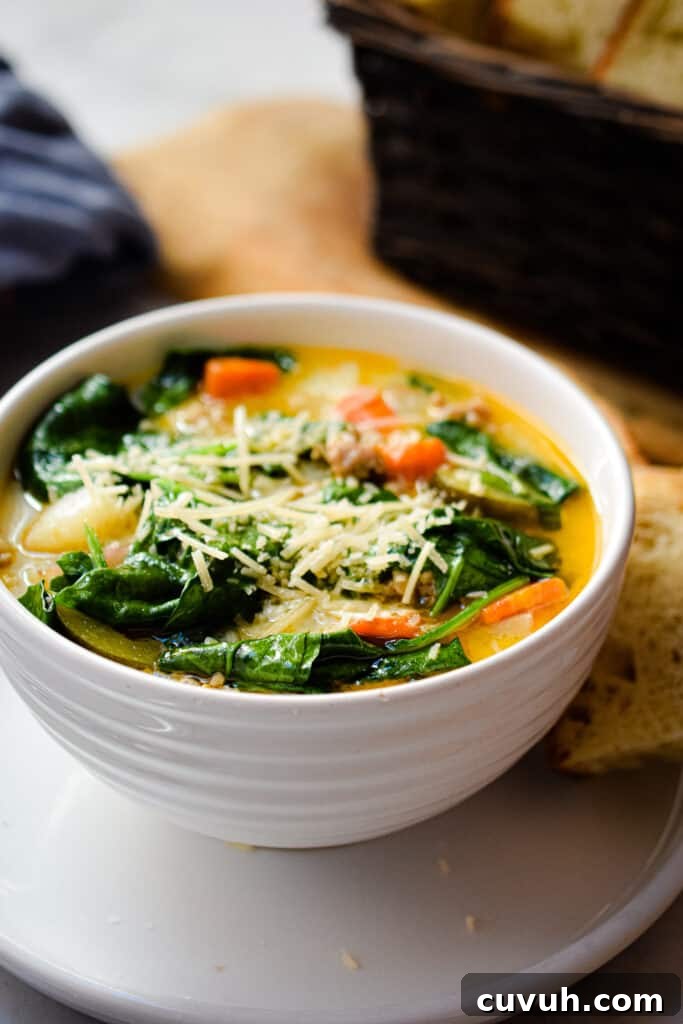 Instant Pot Zuppa Toscana: Sausage and Spinach Soup Recipe 11 The soup is in a bowl and a basket of bread is behind the soup