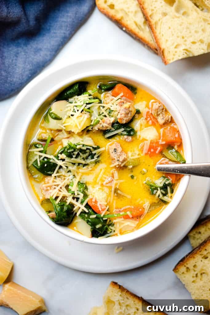 Instant Pot Zuppa Toscana: Sausage and Spinach Soup Recipe 3 An overhead view of the Instant Pot Zuppa Toscana with bread and a blue linen surrounding the bowl.