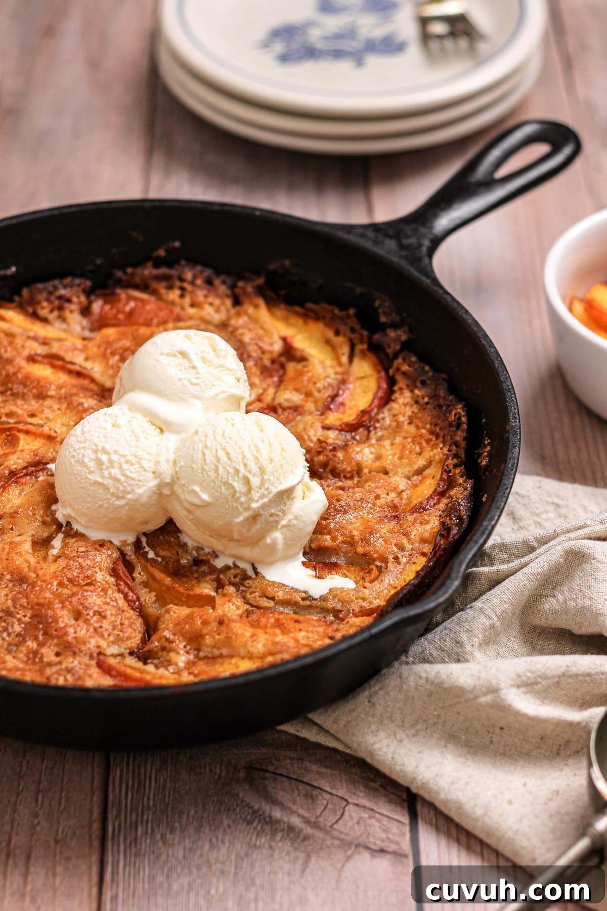 nectarine peach cobbler in a cast iron skillet with vanilla ice cream