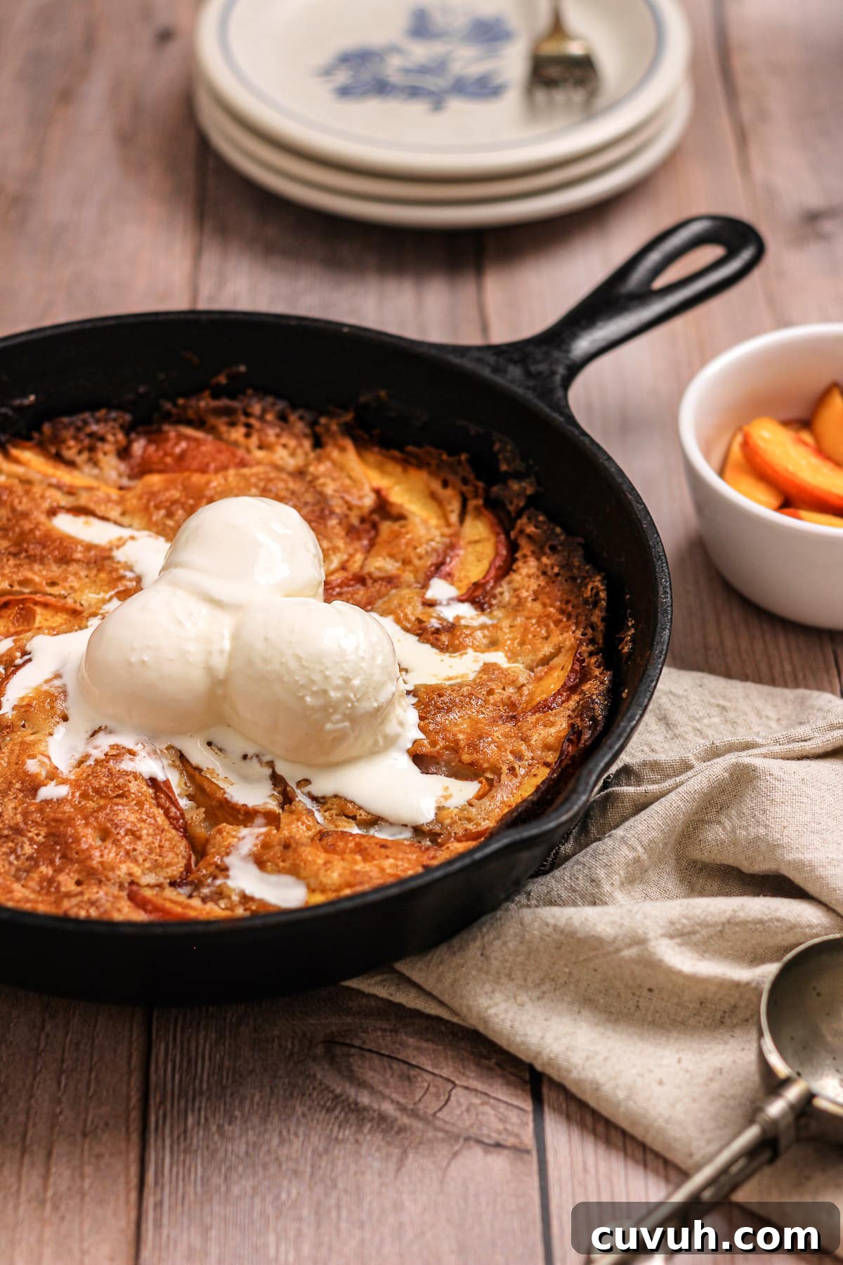 nectarine peach cobbler in a cast iron skillet with vanilla ice cream