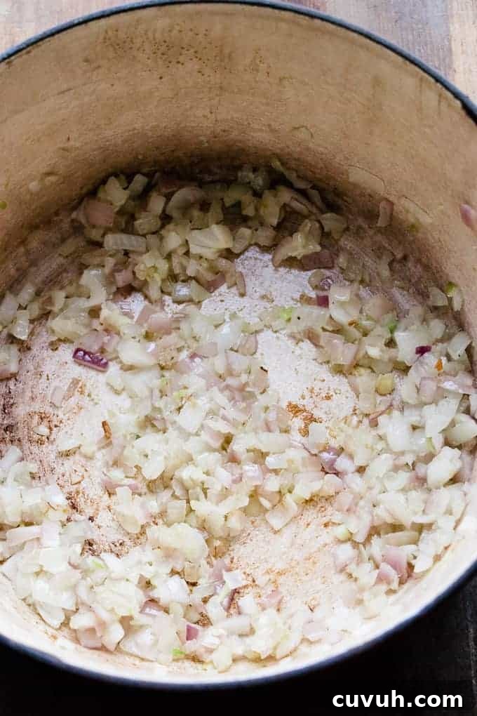 Onions and garlic being heated in a pan with sea salt.