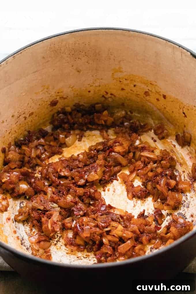 Spices being added to onions and garlic for bean stew.