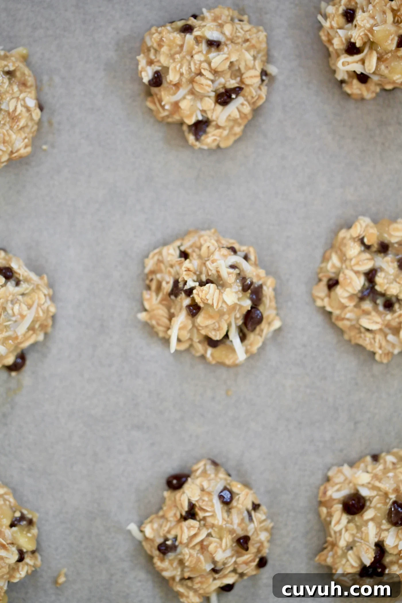 Banana Oatmeal Breakfast Cookies for Quick Morning Fuel 8 unbaked cookies on sheet.