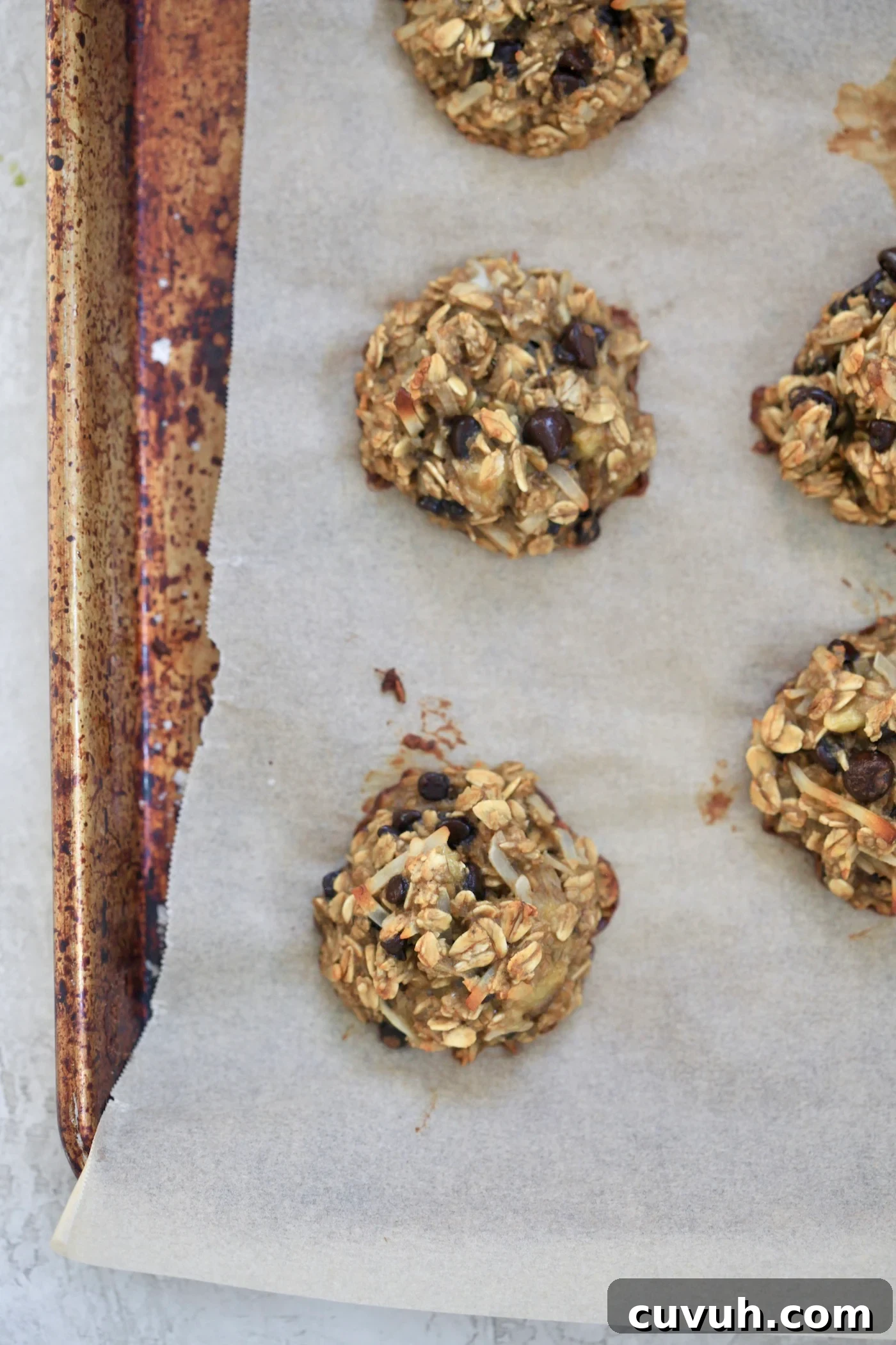 Banana Oatmeal Breakfast Cookies for Quick Morning Fuel 9 baked cookies on sheet.