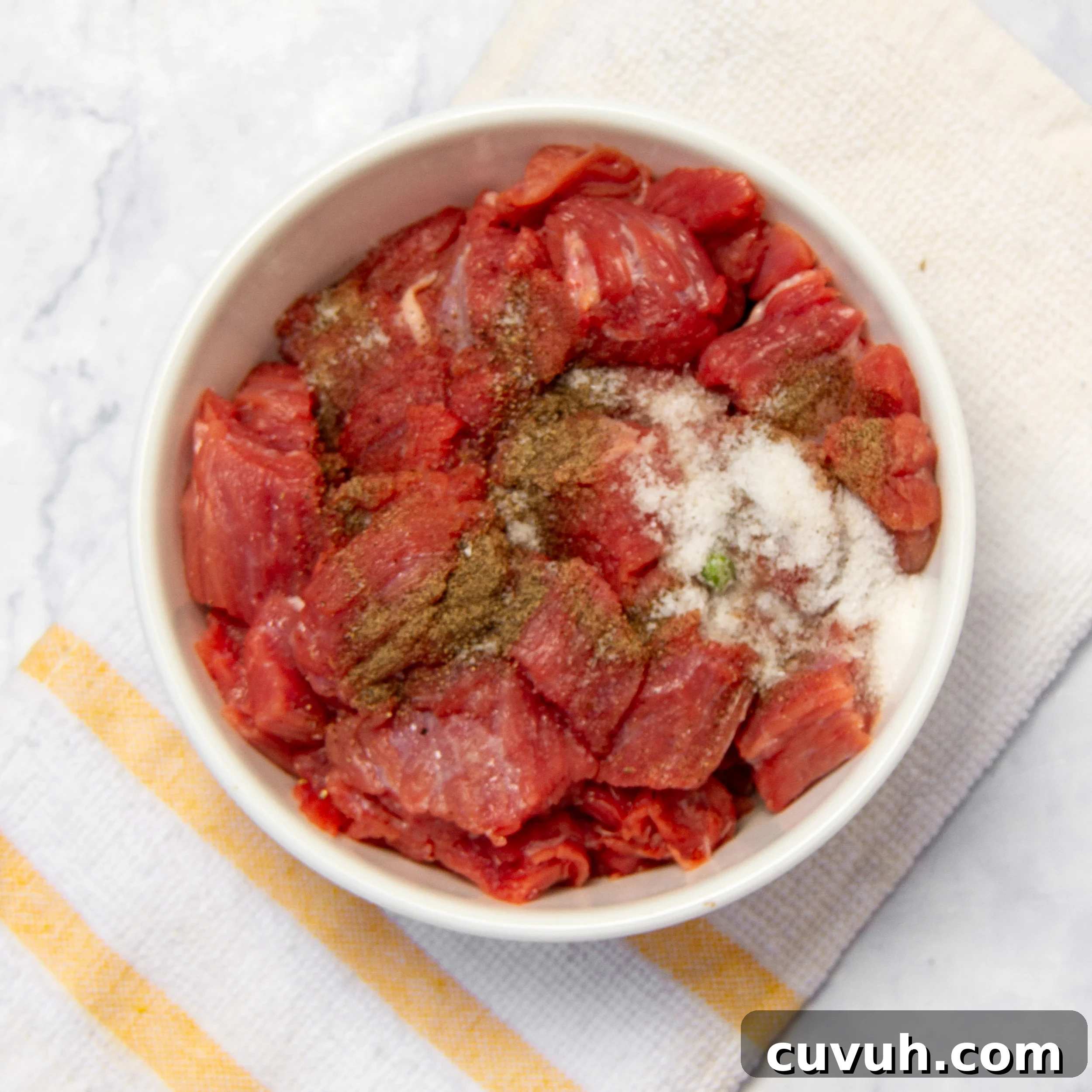 Mulligan Stew Recipe: Hearty One-Pot Comfort Meal 4 Cubed beef sirloin with seasonings in a small bowl.