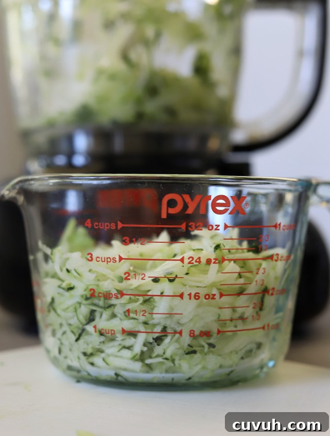 measuring cup with 3 cups shredded zucchini for gluten-free zucchini bread