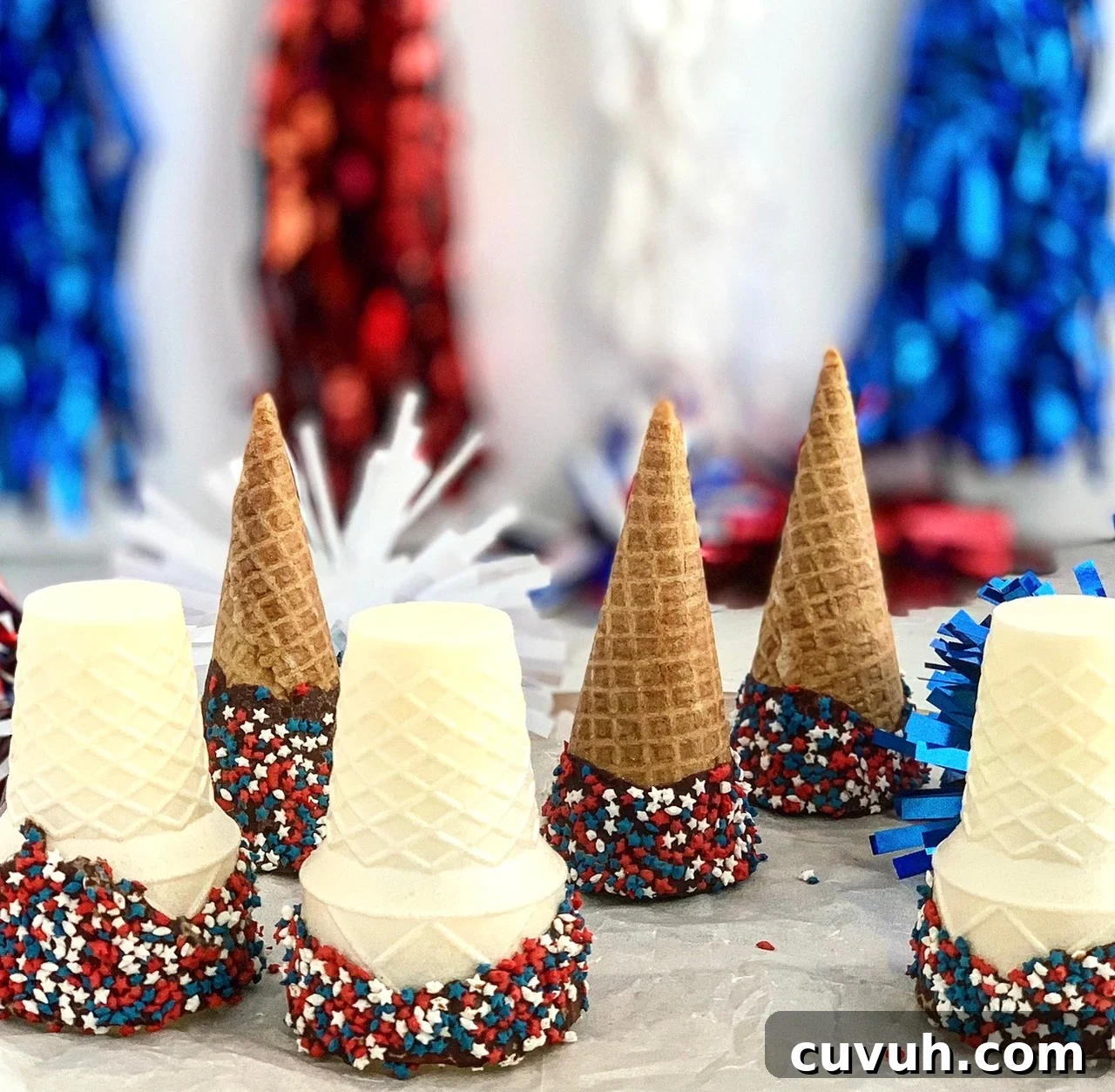 Patriotic 4th of July Desserts to Impress Your Guests 11 ice cream cones that have been dipped in chocolate and sprinkles added.