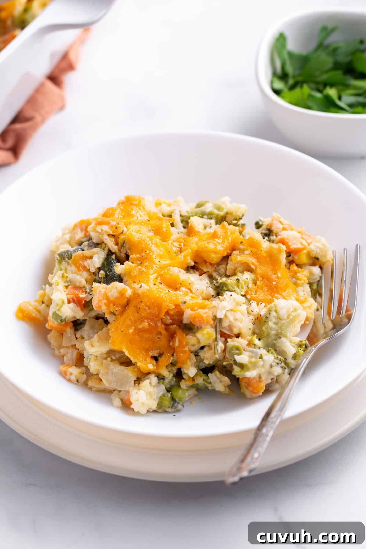 Hearty Seasonal Vegetable Casserole Recipe for Family Meals 10 serving of vegetable casserole served on a white plate with a silver fork