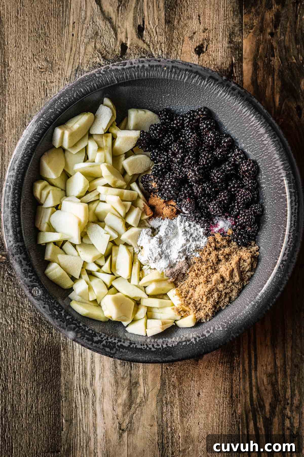 Apple and Blackberry Crumble Recipe for Perfect Autumn Dessert 5 A bowl of chopped apples, blackberries, sugar and spices before mixing.
