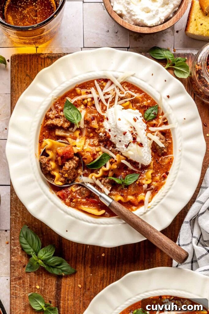 High-protein lasagna soup in a bowl topped with dairy-free ricotta, basil, and chili flakes