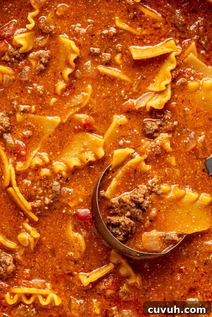 Close-up of creamy lasagna soup with broken lasagna noodles, ground beef, and ricotta.