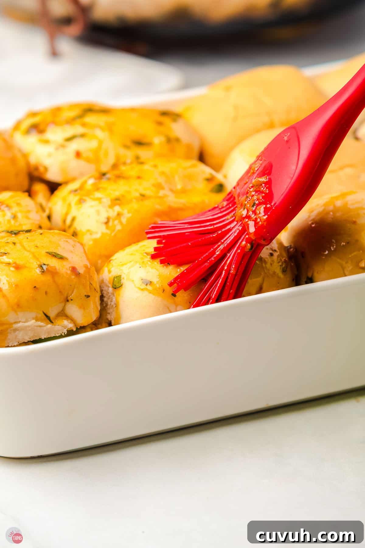 slider buns with butter being brushed on the top