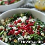 close up of kale salad topped with pomegranate seeds