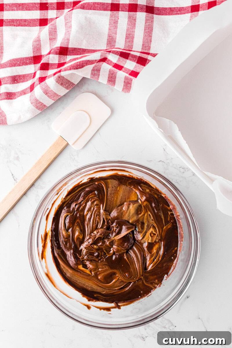 melted frosting and peanut butter mixed together in large glass bowl.