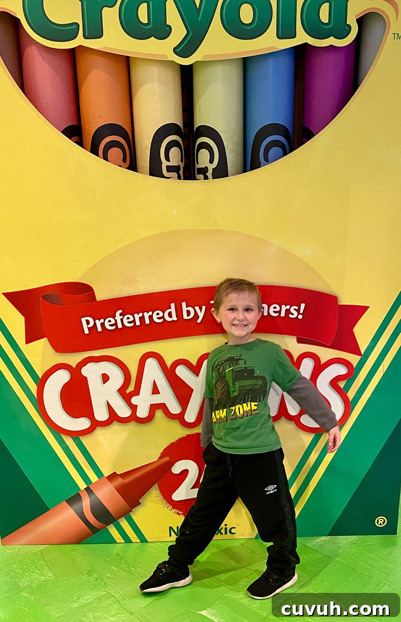 happy boy in front of crayon box at plano crayola experience