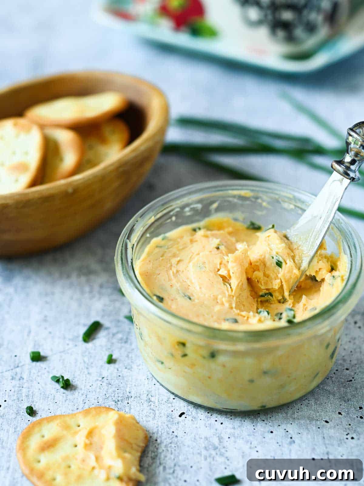 Smoked Chive Butter Recipe: Savory Compound Butter for Bread & Steak 2 Smoked chive butter in a clear bowl with crackers on the side.