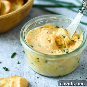 Smoked Chive Butter Recipe: Savory Compound Butter for Bread & Steak 13 Close-up of chive butter in a clear bowl on a grey surface.