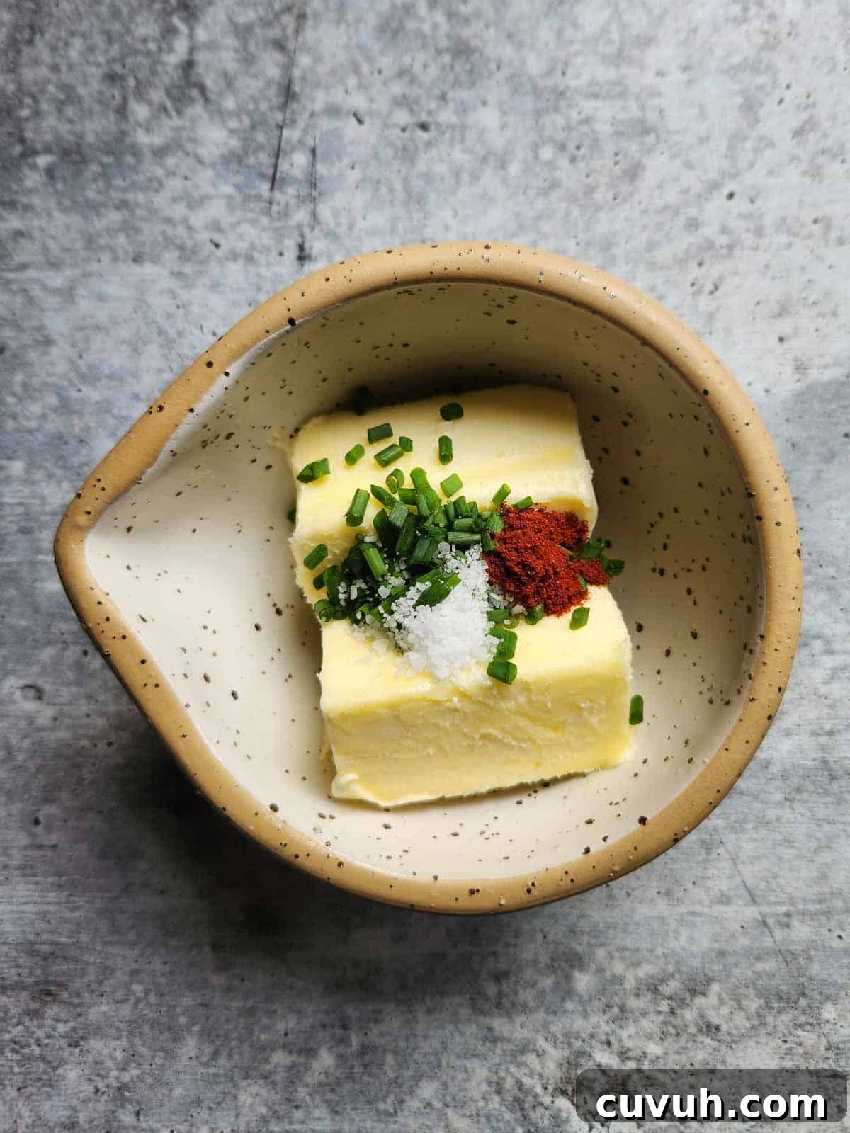 Smoked Chive Butter Recipe: Savory Compound Butter for Bread & Steak 4 Butter, chives, and spices in a small beige bowl.