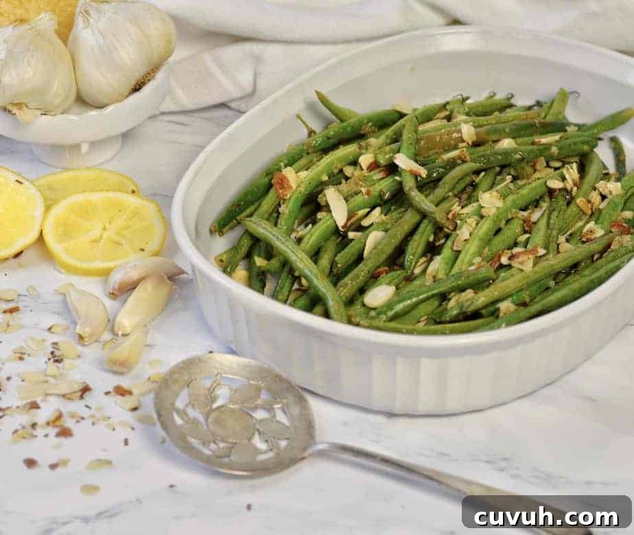 white dish with roasted lemon garlic green beans and almonds