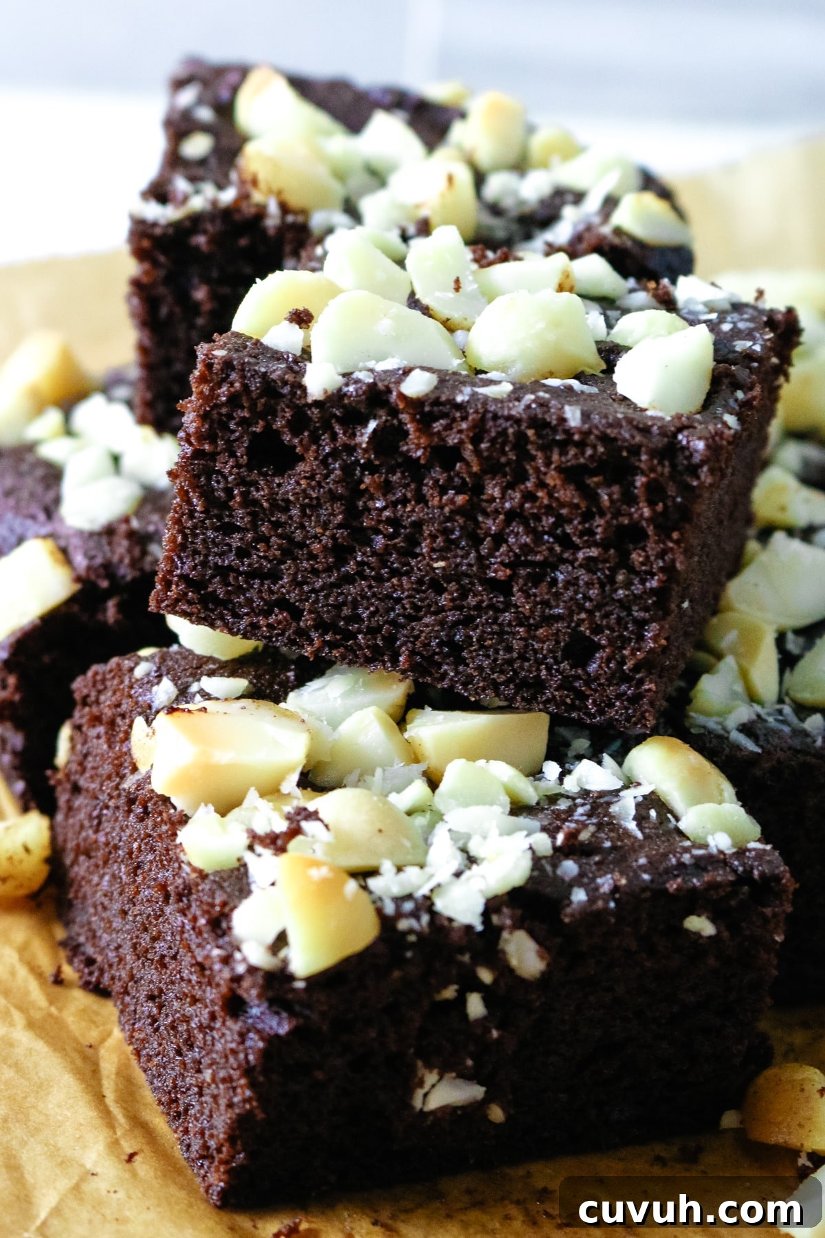 The coconut flour brownies are arranged on parchment paper.