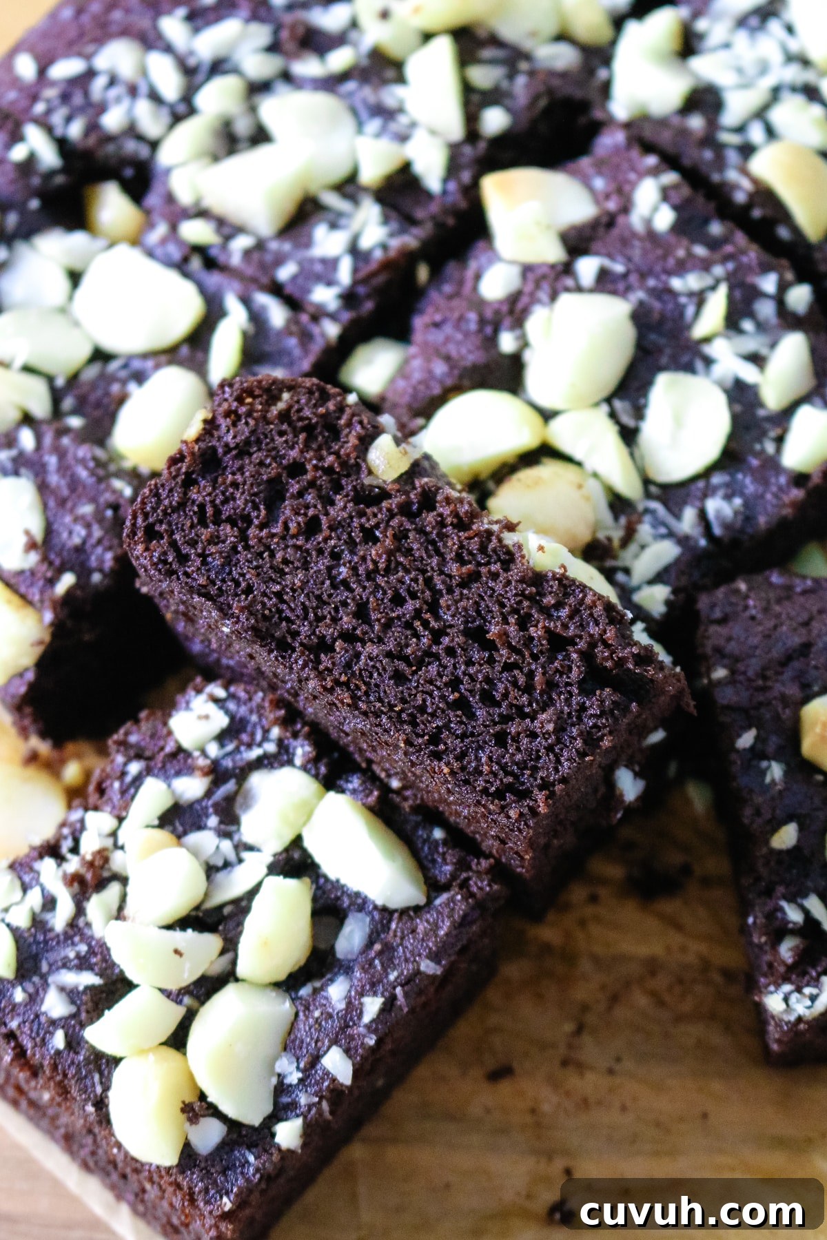 The coconut flour brownies are arranged on parchment paper.