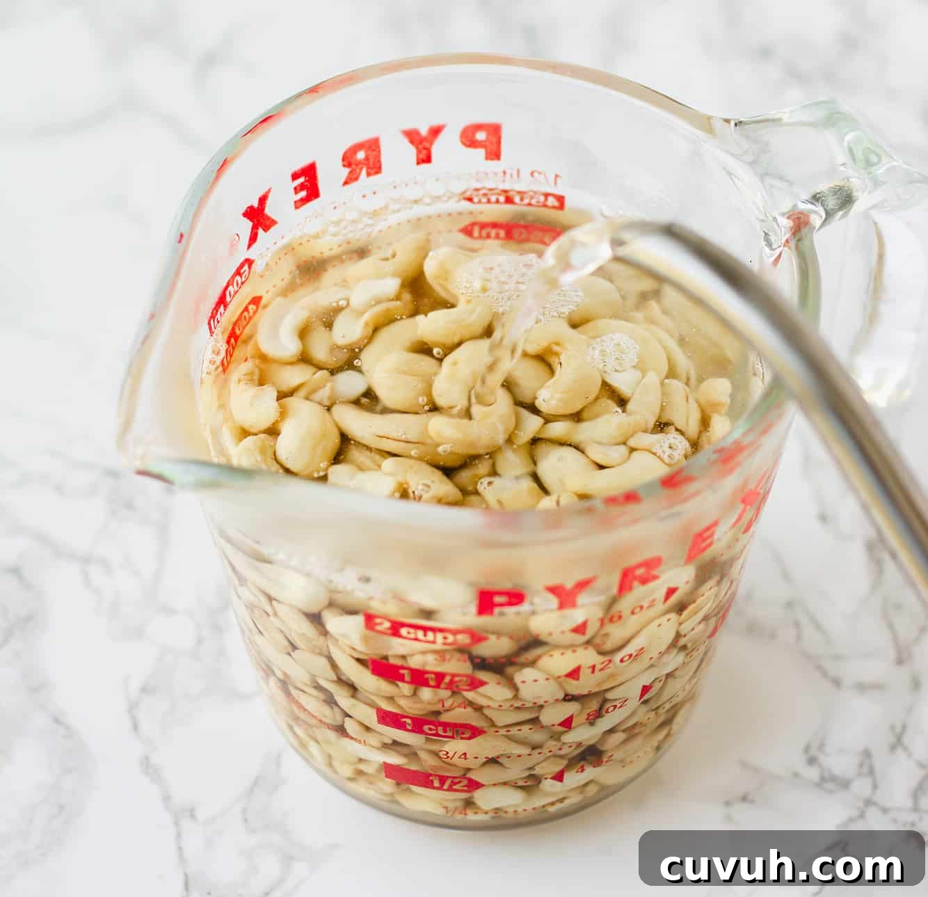 Creamy Vegan Ranch Dressing Recipe for Salads & Dips 3 soaking cashews in hot water in a large glass measuring cup.