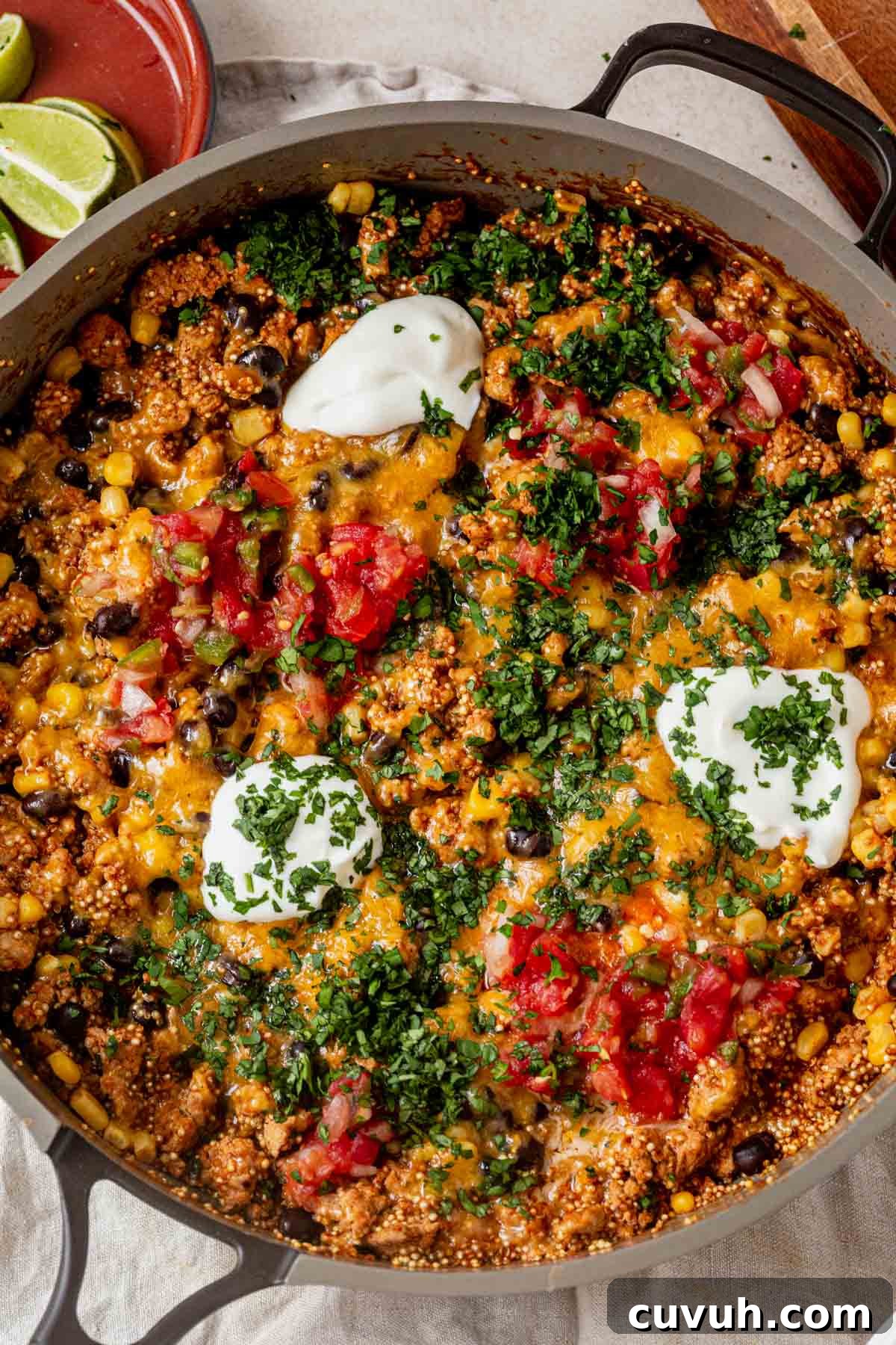 One pan enchilada quinoa skillet topped with sour cream, pico de gallo, and chopped cilantro.