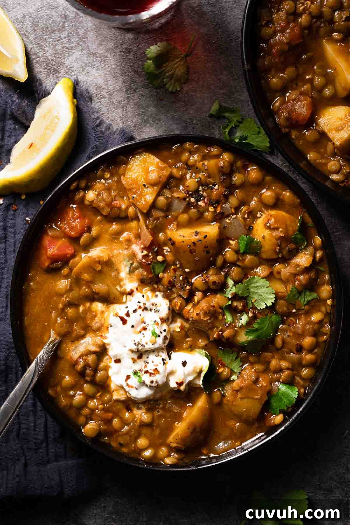 Hearty Lentil and Potato Soup Recipe for Comforting Weeknight Meals 2 lentil potato soup in two bowls with spoon in bowl and two lemon wedges on the side