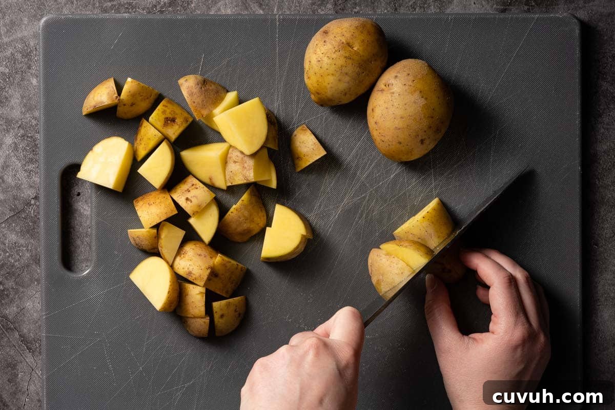 Hearty Lentil and Potato Soup Recipe for Comforting Weeknight Meals 5 potatoes being cut into chunks on cutting board