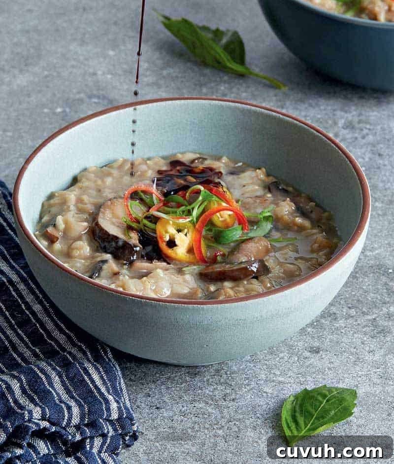 Mushroom & Ginger Steel-Cut Oatmeal Congee (Vegan) 5 Soy sauce being poured on a bowl of mushroom congee.