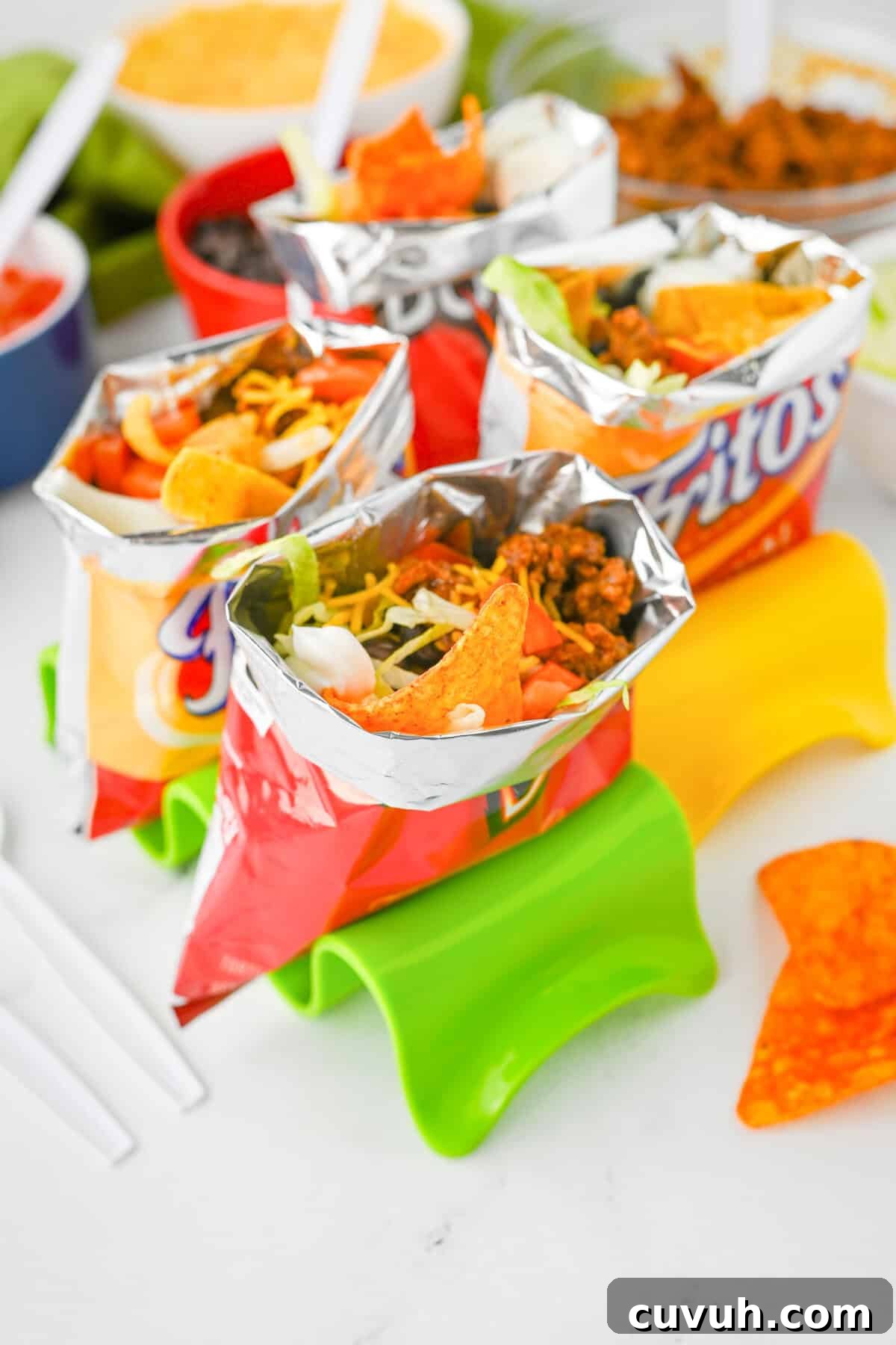 How to Make Walking Tacos: Quick Party-Friendly Recipe 5 Multiple walking tacos served in open bags of Fritos and Doritos, filled with seasoned ground beef, shredded cheese, chopped tomatoes, lettuce, black beans, and sour cream.