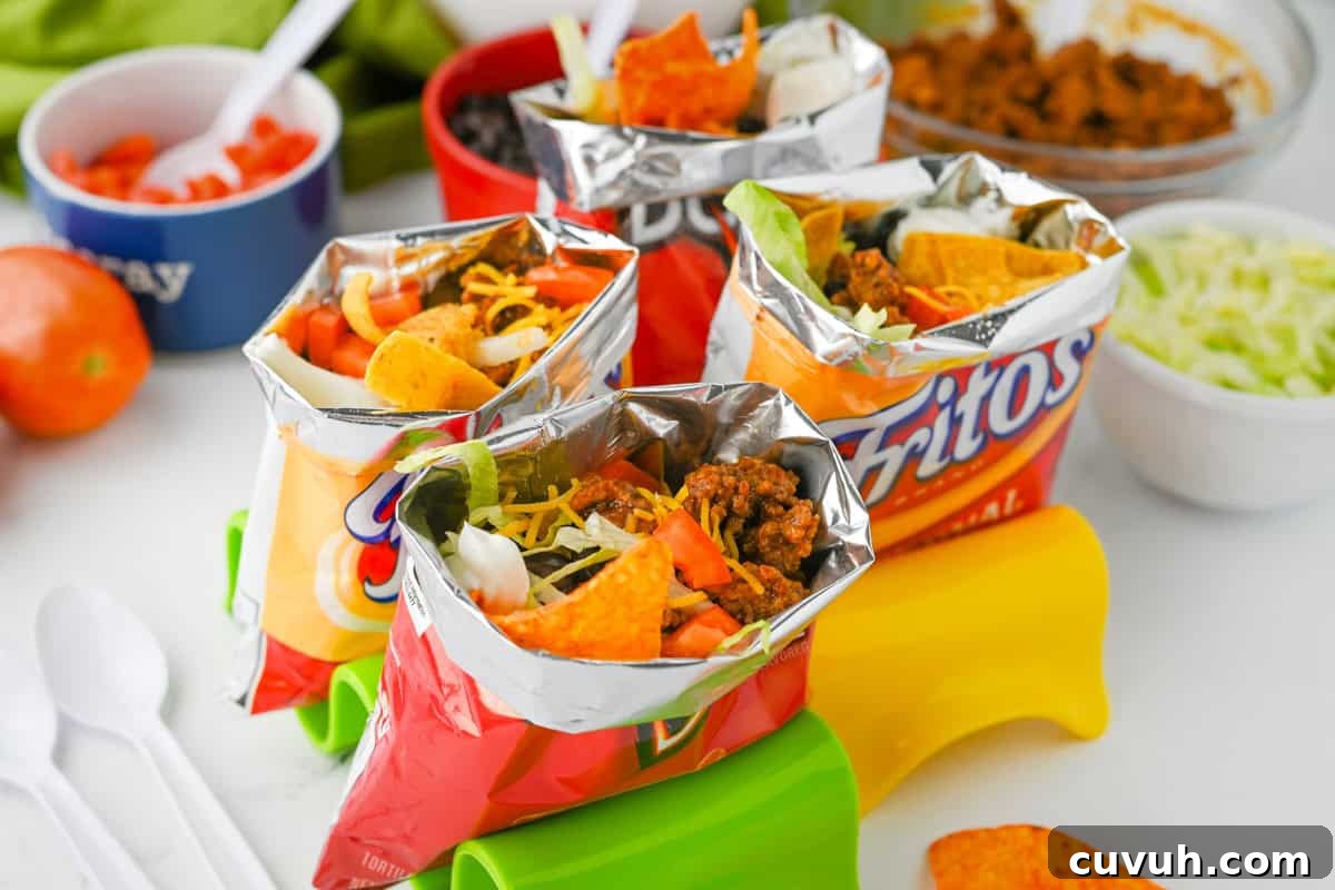 How to Make Walking Tacos: Quick Party-Friendly Recipe 6 Several walking tacos in chip bags with toppings.