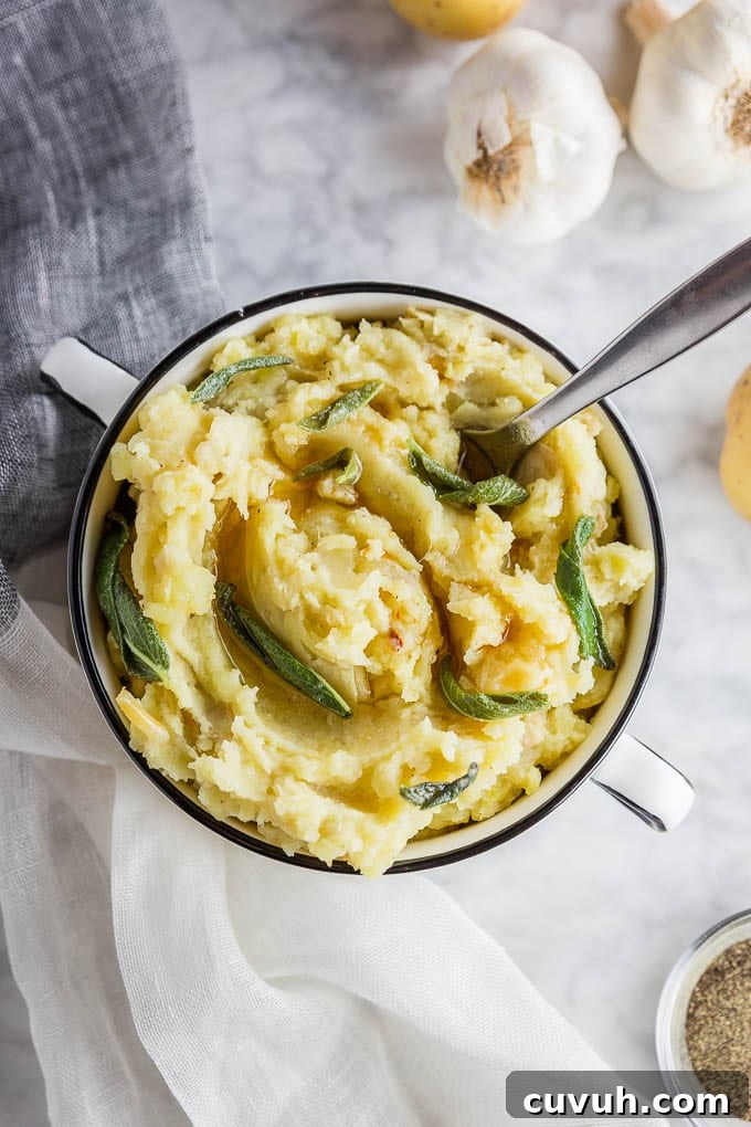 Roasted Garlic Mashed Potatoes with Brown Butter & Sage 2 A bowl of roasted garlic mashed potatoes with brown butter and fresh sage leaves.