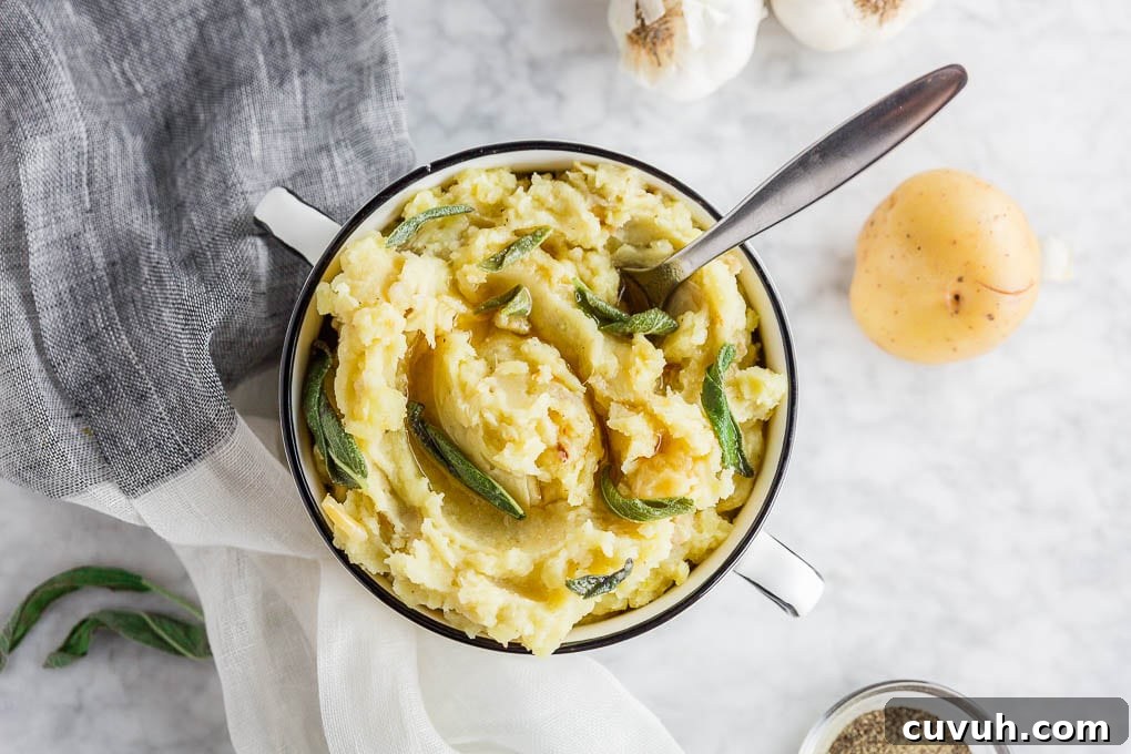 Roasted Garlic Mashed Potatoes with Brown Butter & Sage 5 A bowl of gluten-free brown butter roasted garlic mashed potatoes with sage wth a spoon.