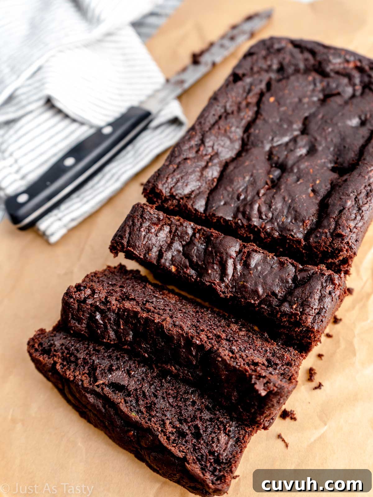 Ultra-Moist Double Chocolate Zucchini Bread — Gluten-Free & Eggless 2 Sliced chocolate zucchini bread on parchment paper.