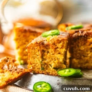 Spicy Jalapeño Honey Cornbread Recipe 11 sliced jalapeno honey cornbread on a plate with spicy honey butter and jalapenos.