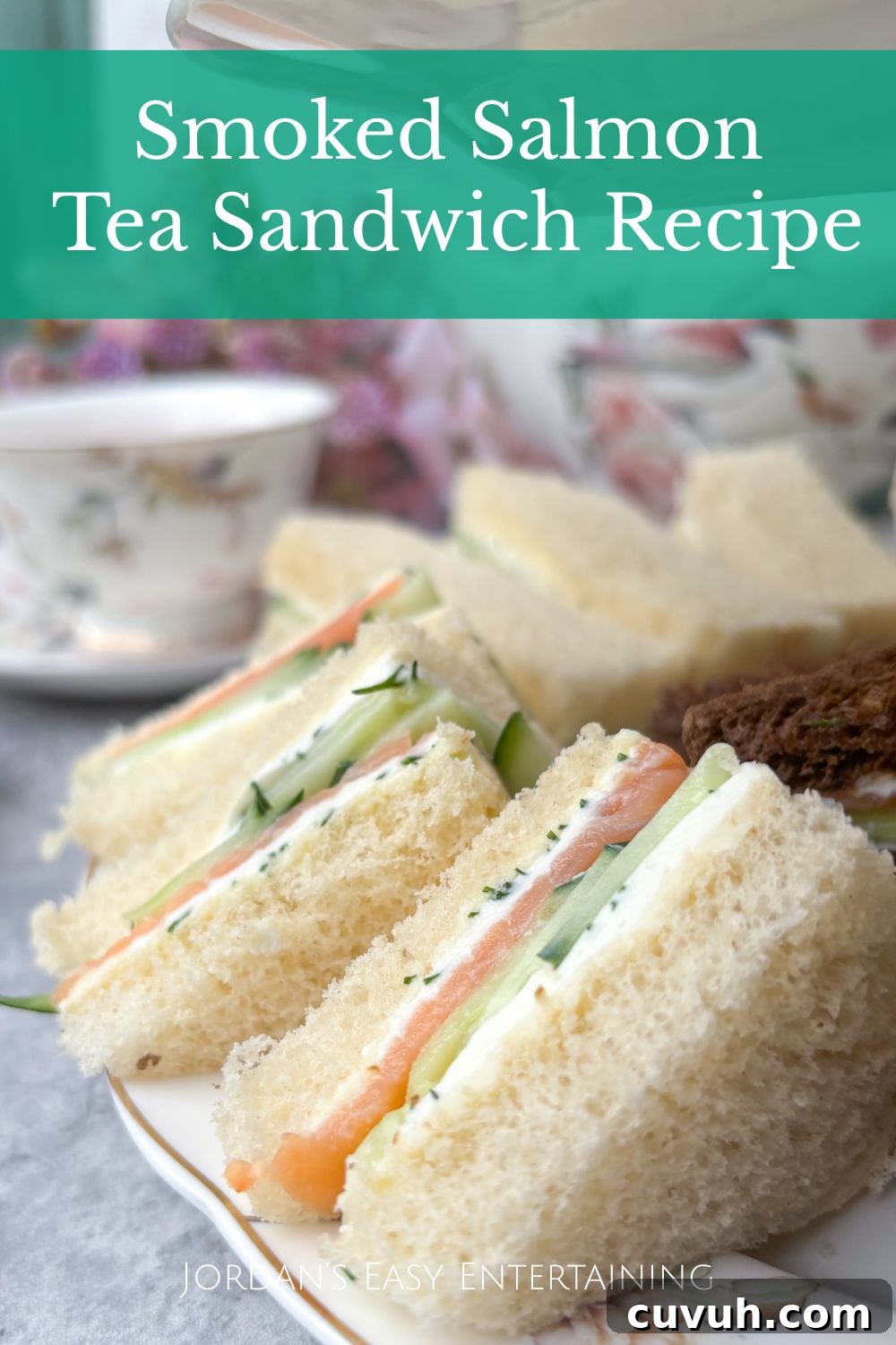 Smoked Salmon Tea Sandwiches with Cream Cheese, Cucumber & Dill 13 Smoked salmon tea sandwiches with cream cheese, cucumber, and dill on a plate with mini quiches and crostini, served alongside floral china tea cups and a matching teapot for an afternoon tea party.