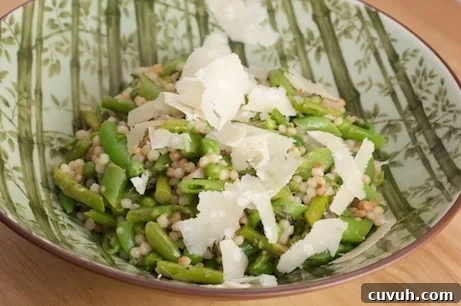 Bowl of Israeli couscous with asparagus and peas.