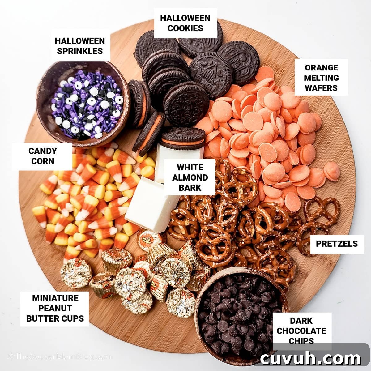 Halloween candy bark ingredients on a serving tray with text labels.