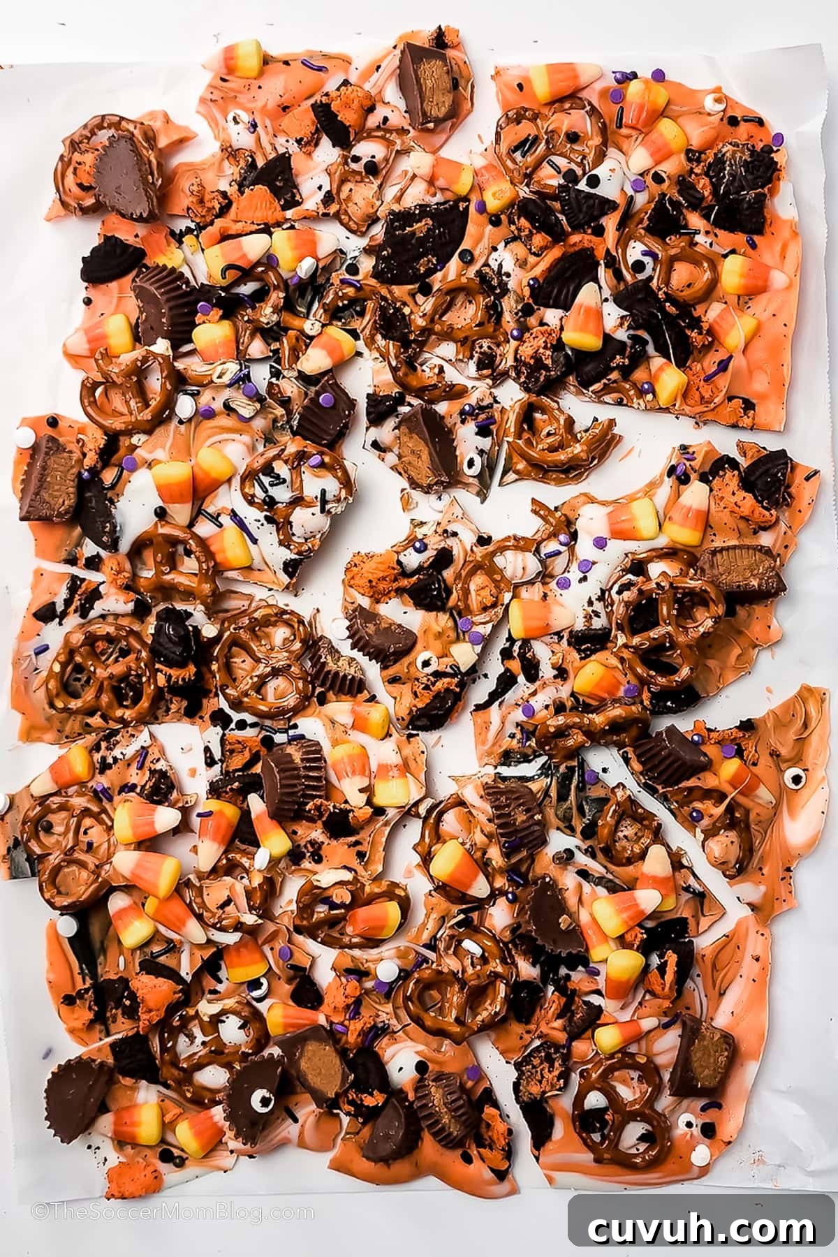 Halloween chocolate bark freshly broken up on parchment paper.