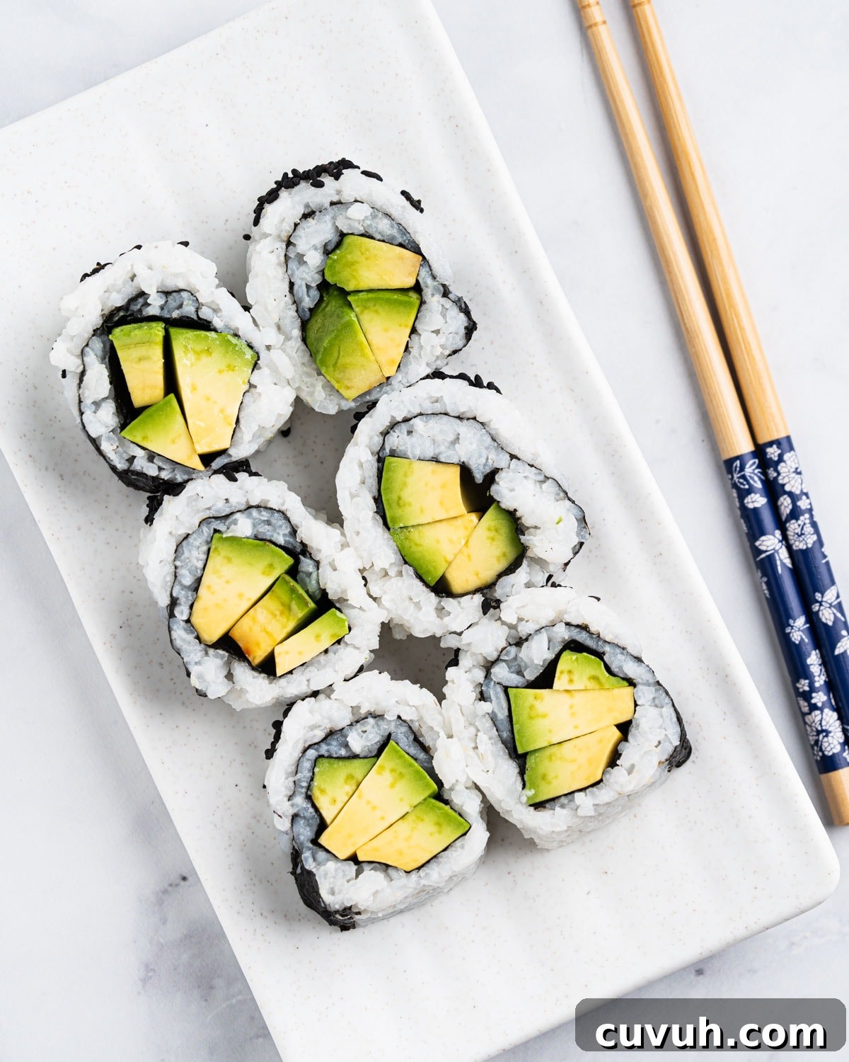 top down view of 6 avocado rolls on a plate.