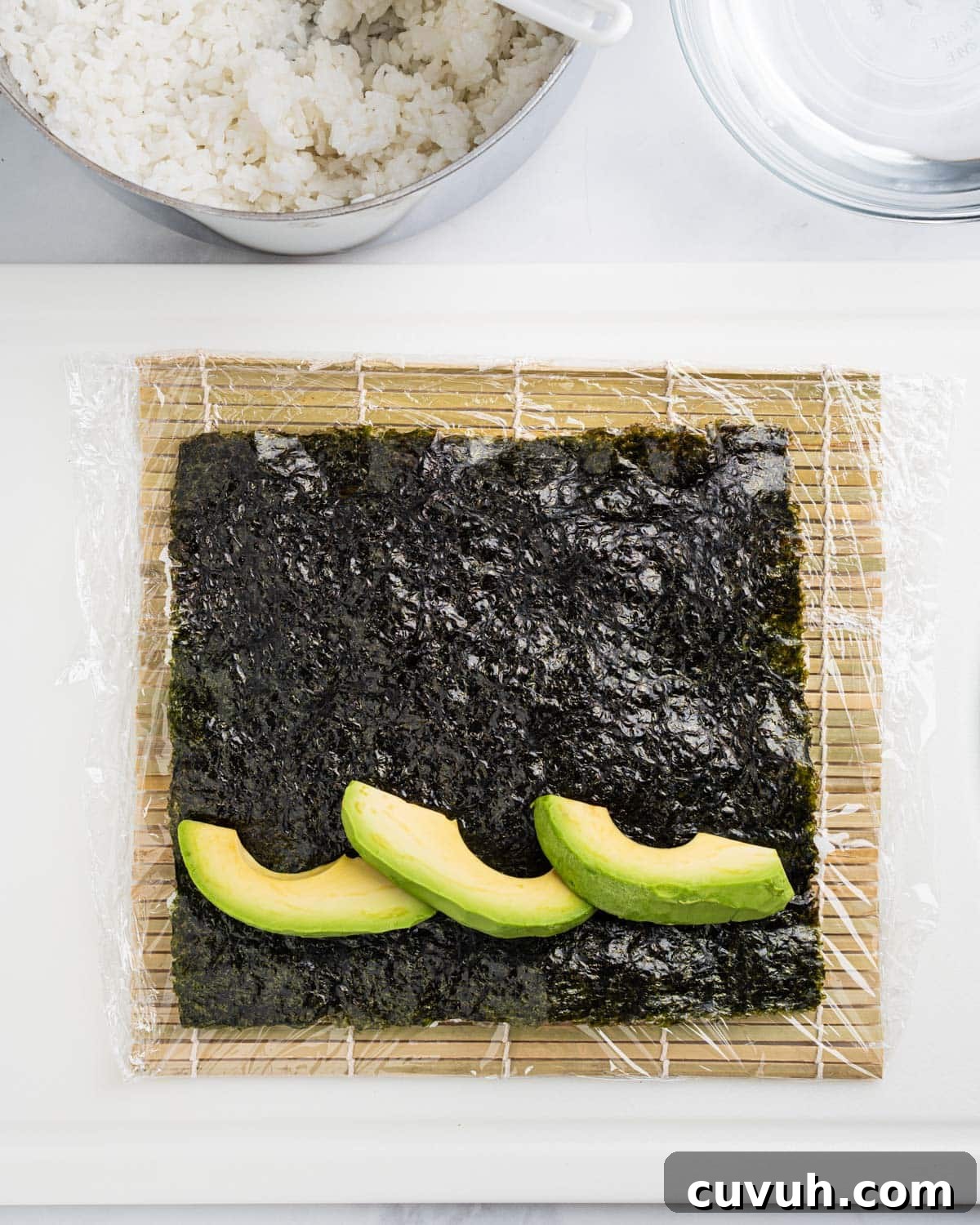 Avocado slices spread evenly on nori seaweed sheet.